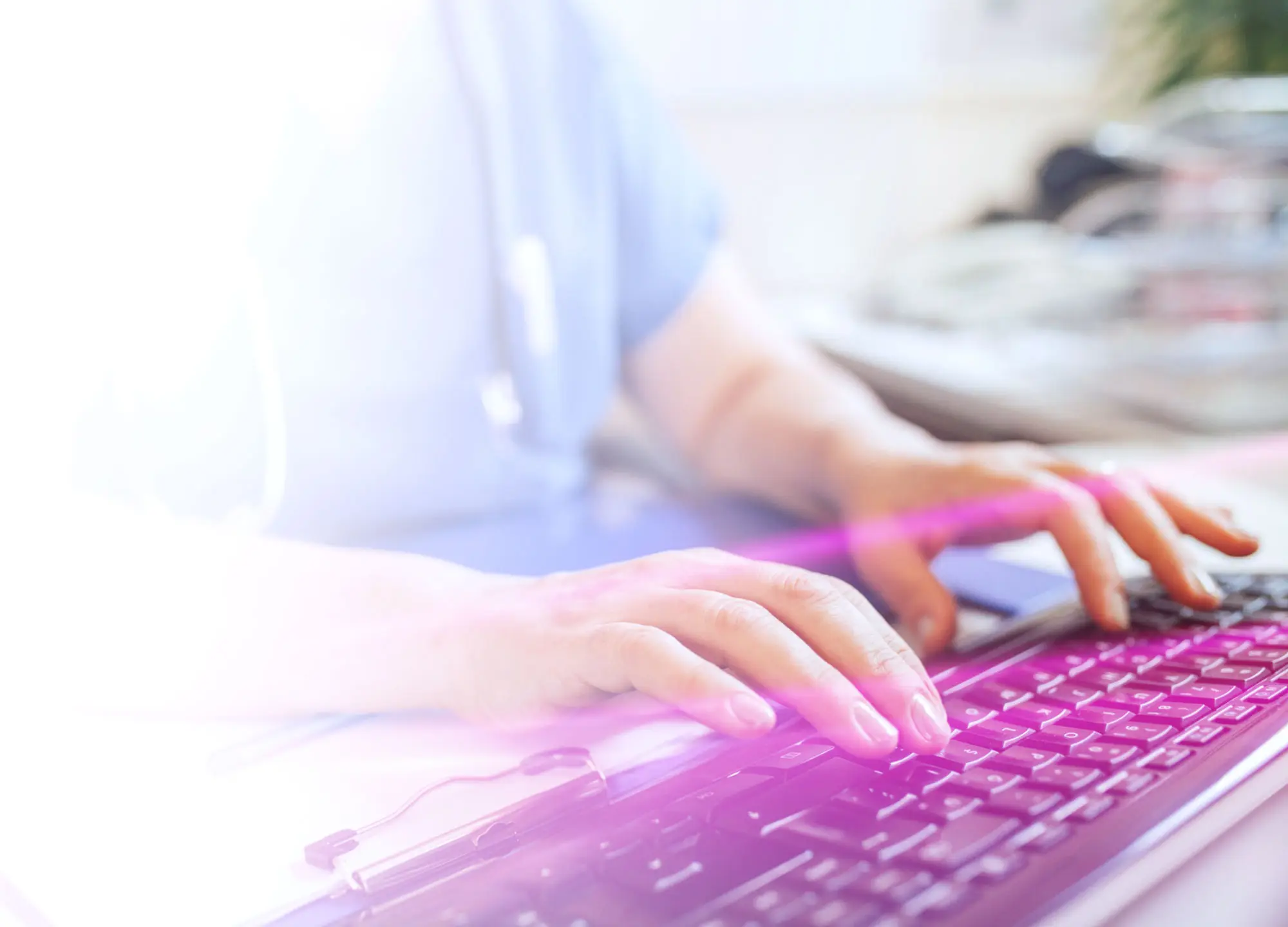 Hands typing on a keyboard with a purple glow and bright white light.